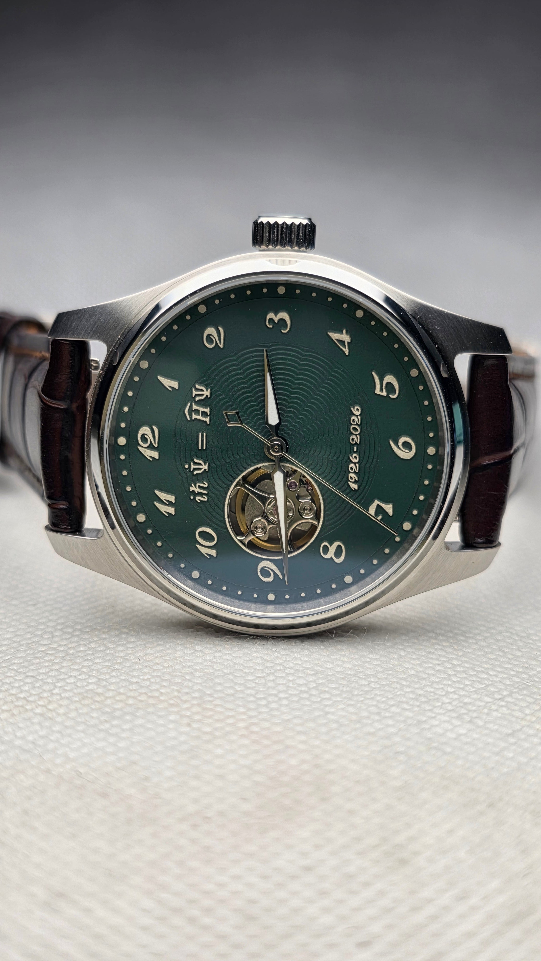 Green open-heart watch with an engraved equation