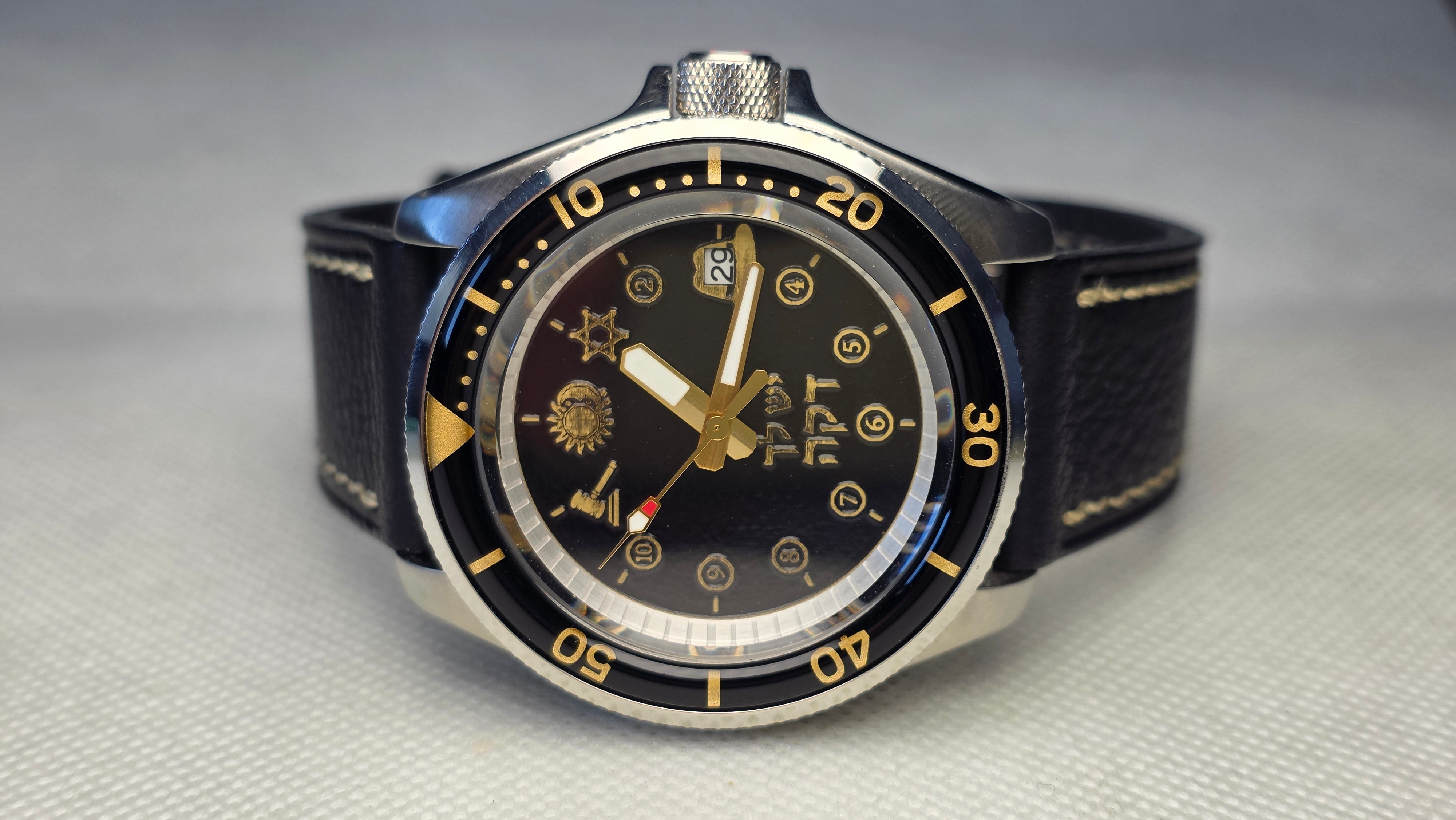 Black and gold custom diver with engraved personal symbols, Hebrew lettering and a date window