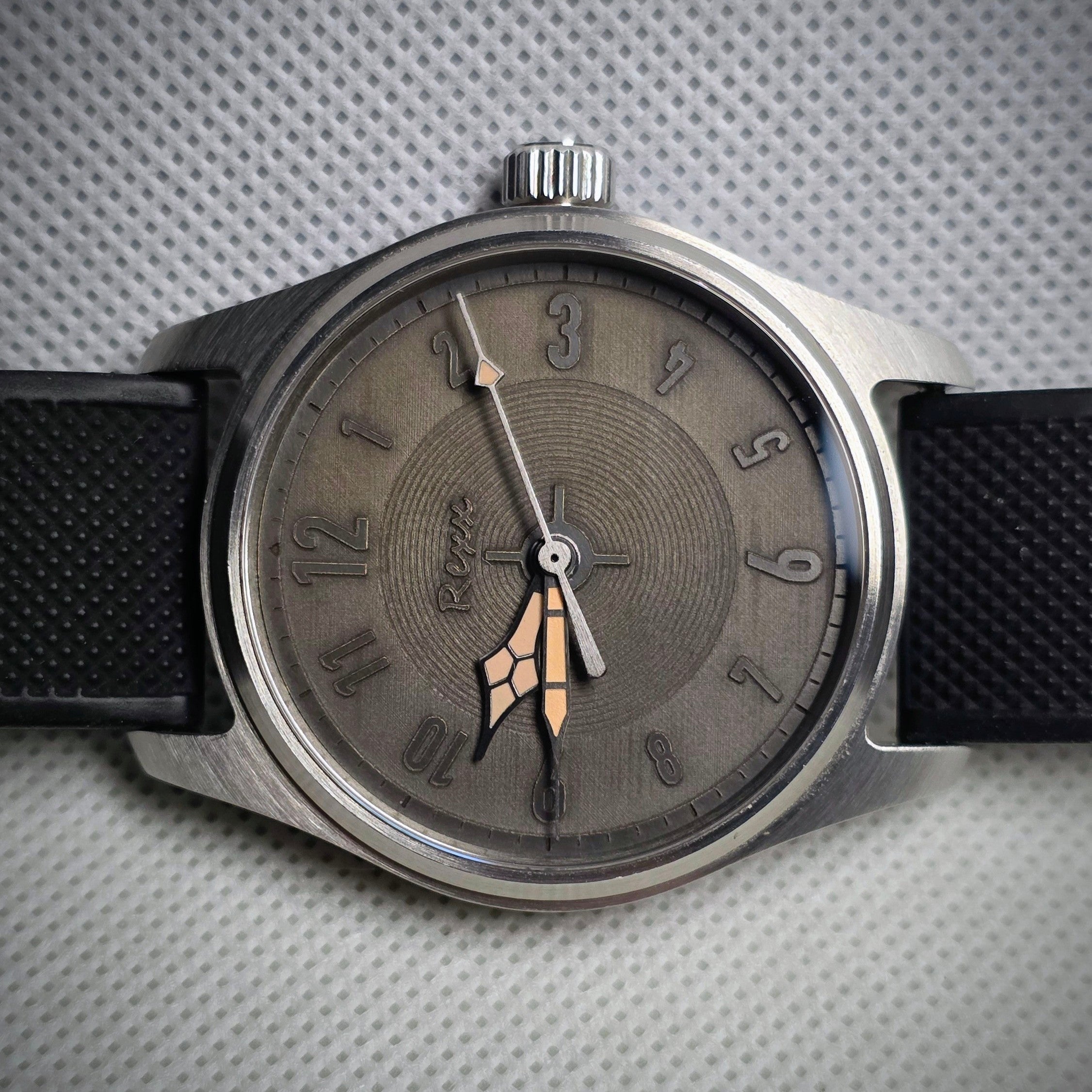 Monochrome engraved custom watch with raised numerals and layered geometric hands