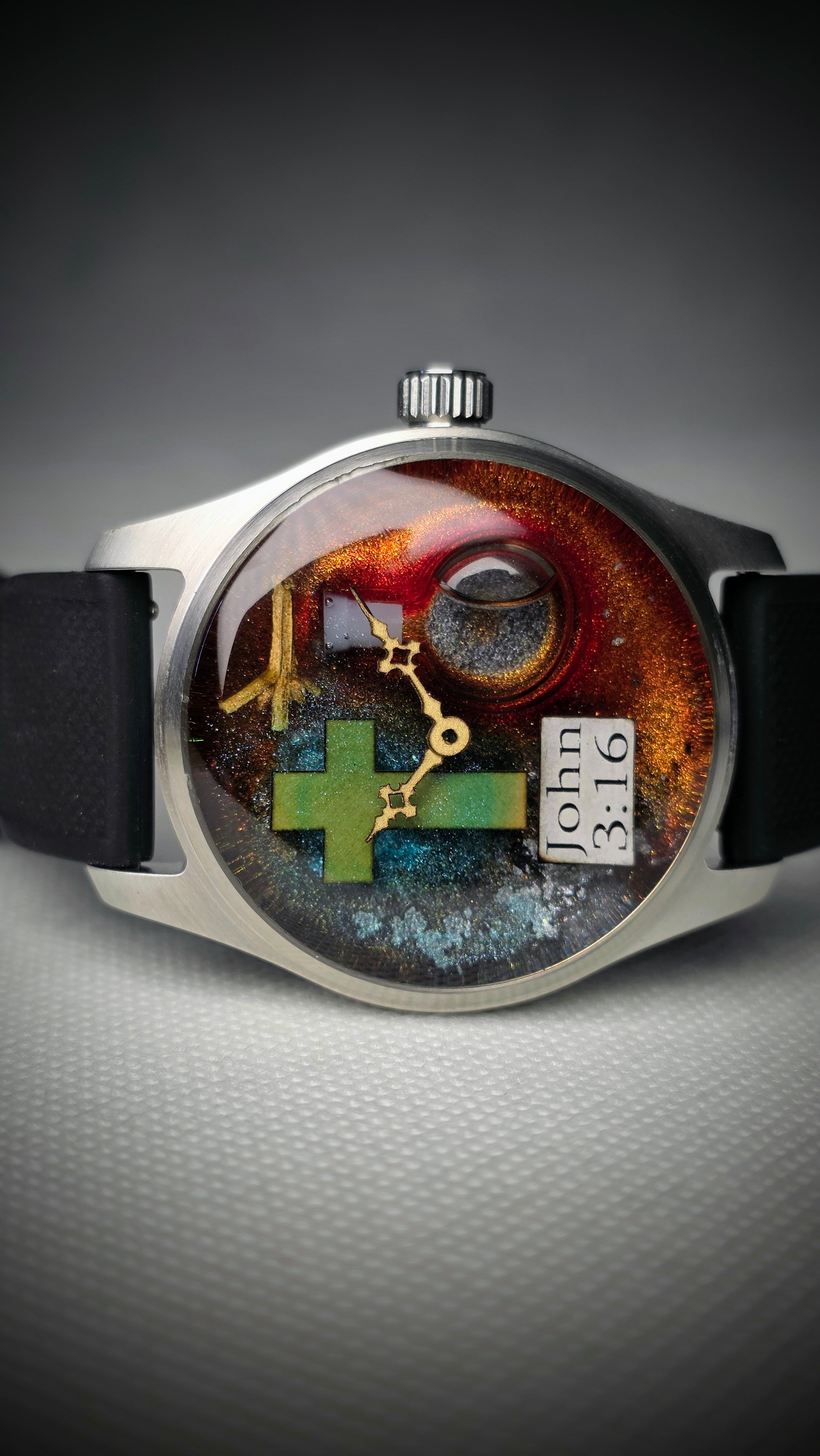 Colour-layered story watch with a cross, eye motif and John 3:16 inscription