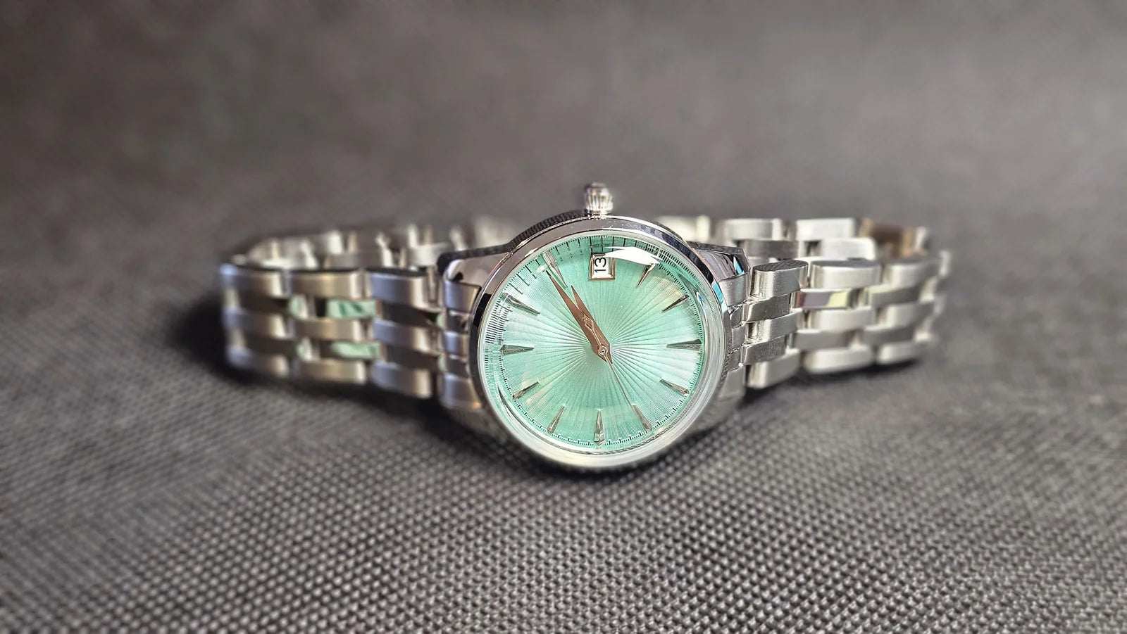 Aqua dial custom watch on a steel bracelet