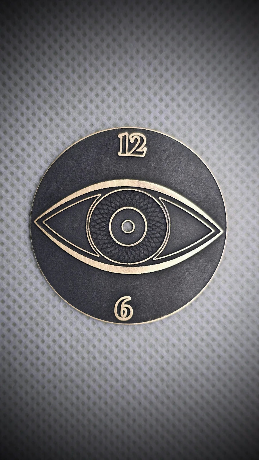 Dark custom watch dial with a brass eye motif and lower numeral