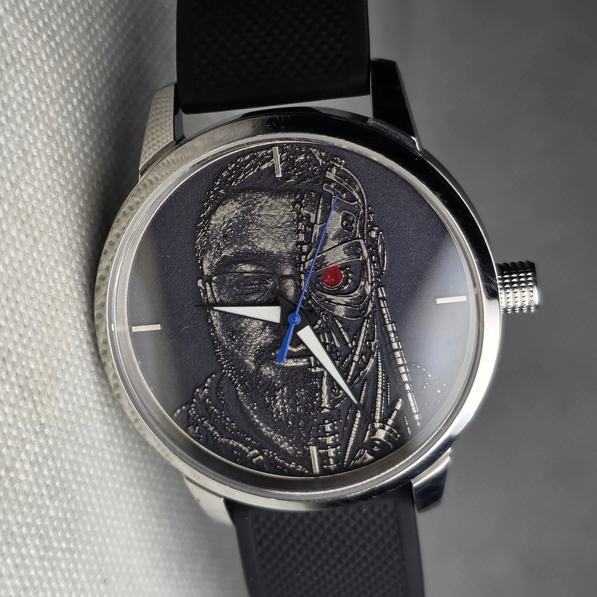 The same watch after its makeover, with a dark engraved cyborg dial, red eye and black strap