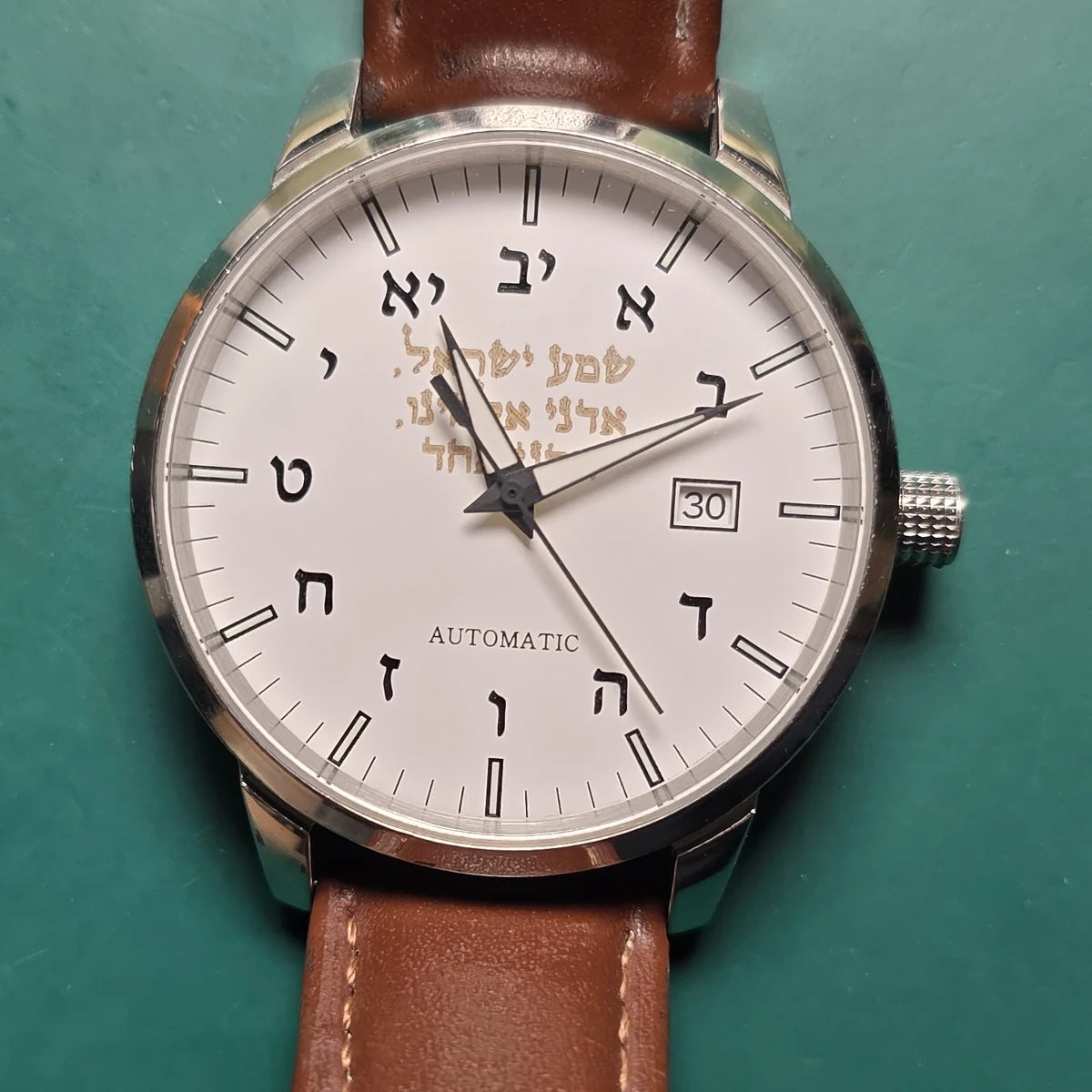Watch before its makeover, with a cream dial, Hebrew numerals and brown leather strap