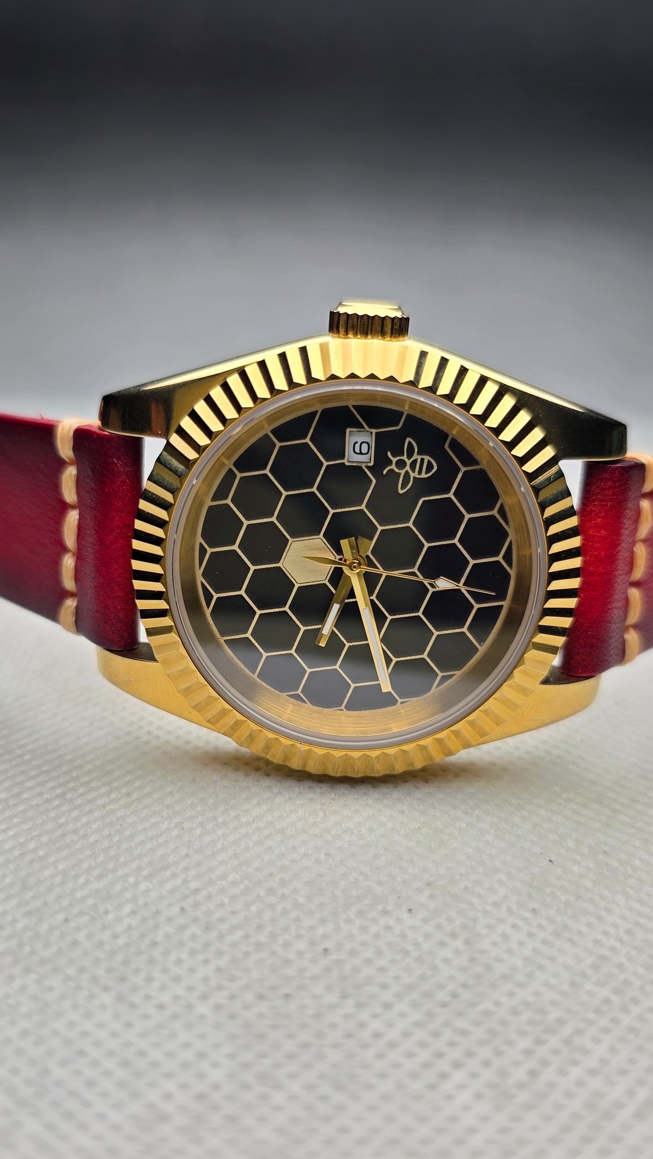Custom honeycomb watch with a gold-tone case and burgundy leather strap