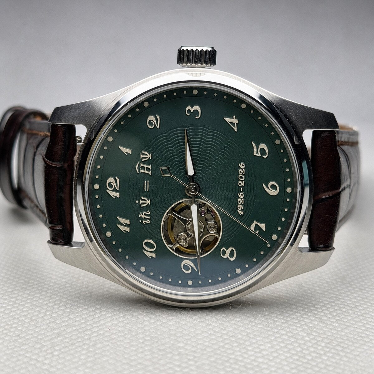Custom mechanical watch with a green open-heart dial carrying the Schrodinger equation and 1926-2026 inscription